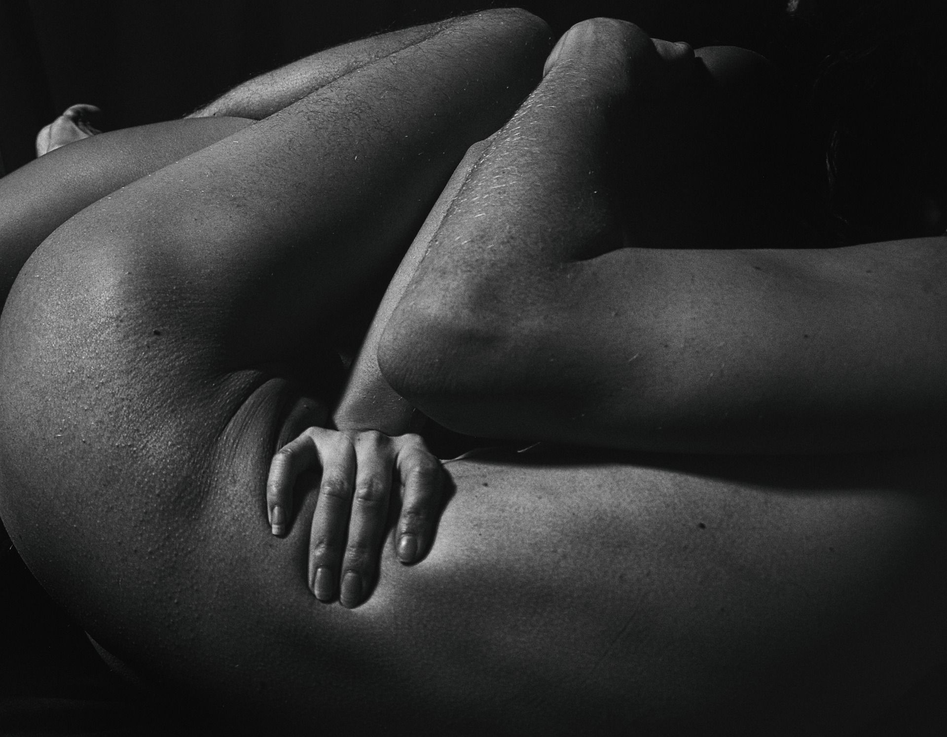 Black and white close-up of a hand resting on bare skin